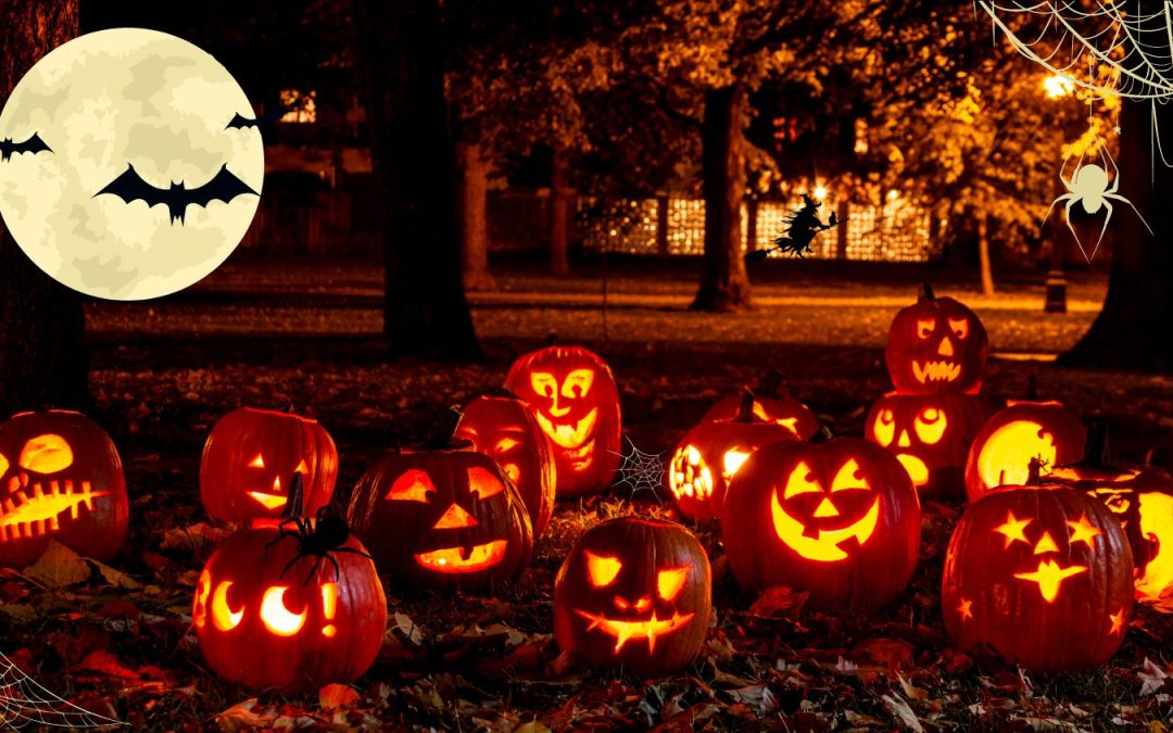 College Campus at night in the fall. Trees, ground covered in leaves. 13 Jack-o-lanterns in the foreground all light up with various faces, a moon with bats in the top left, a witch on a broom in the background in front of a lighted window, with some spider webs and spiders scattered around