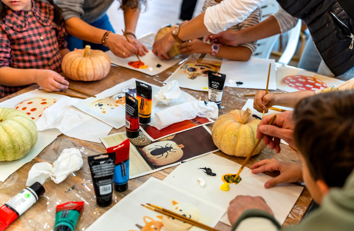 preschoolers painting pumpkins with adult help